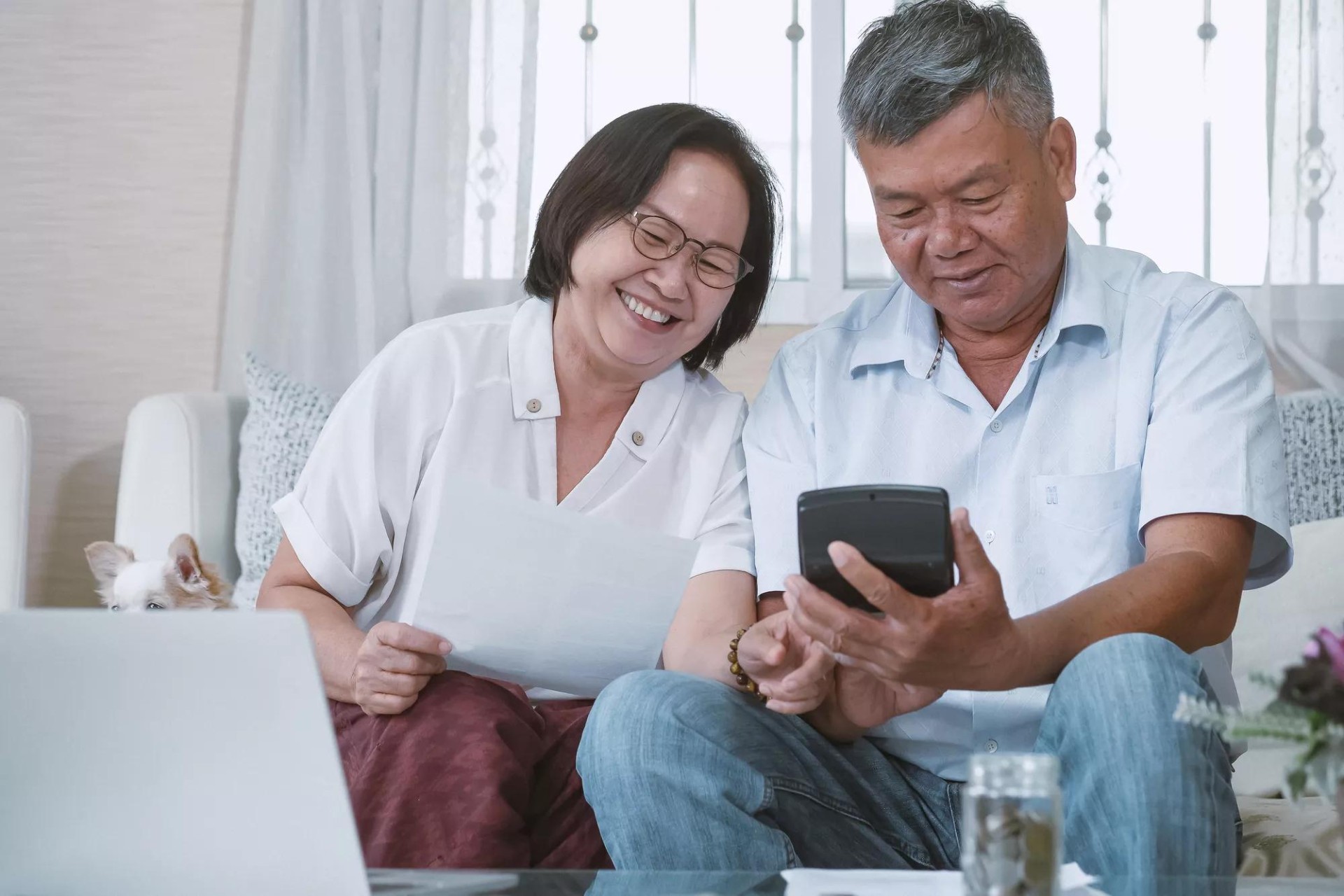 Happy couple calculating savings from picking a dental plan Happy couple calculating savings from picking a dental plan